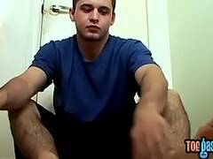 Horny jock takes his shoes off for bare feet masturbation