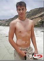 Dark haired guy strips on the beach