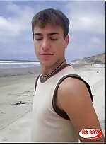 Dark haired guy strips on the beach